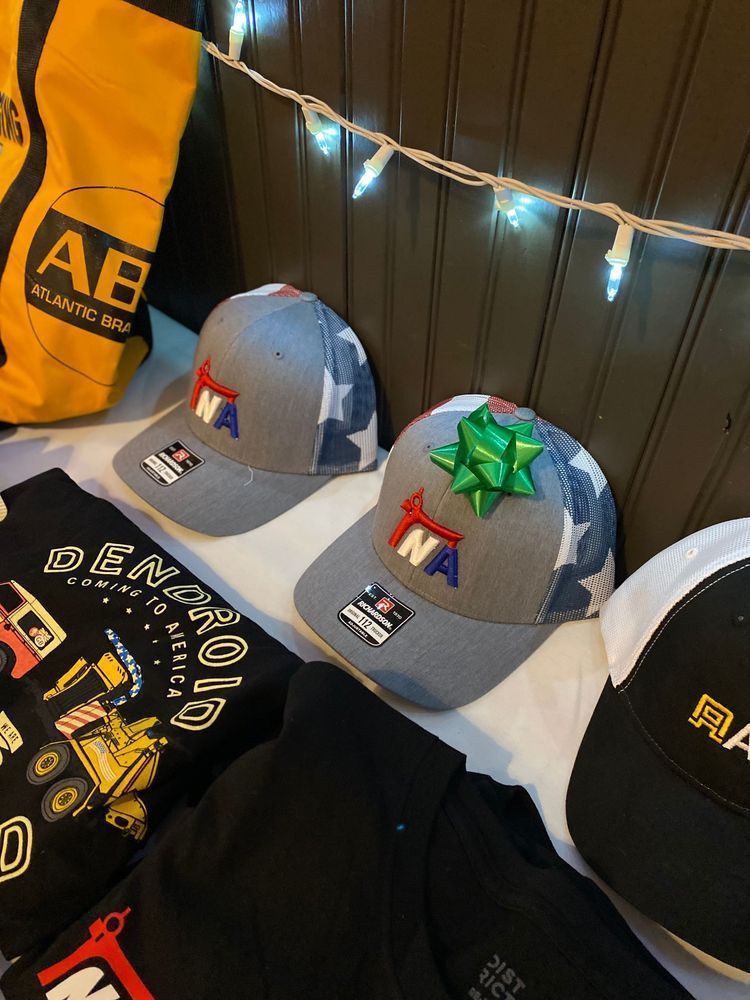 A bunch of hats are on a bed with a bag that says ab on it