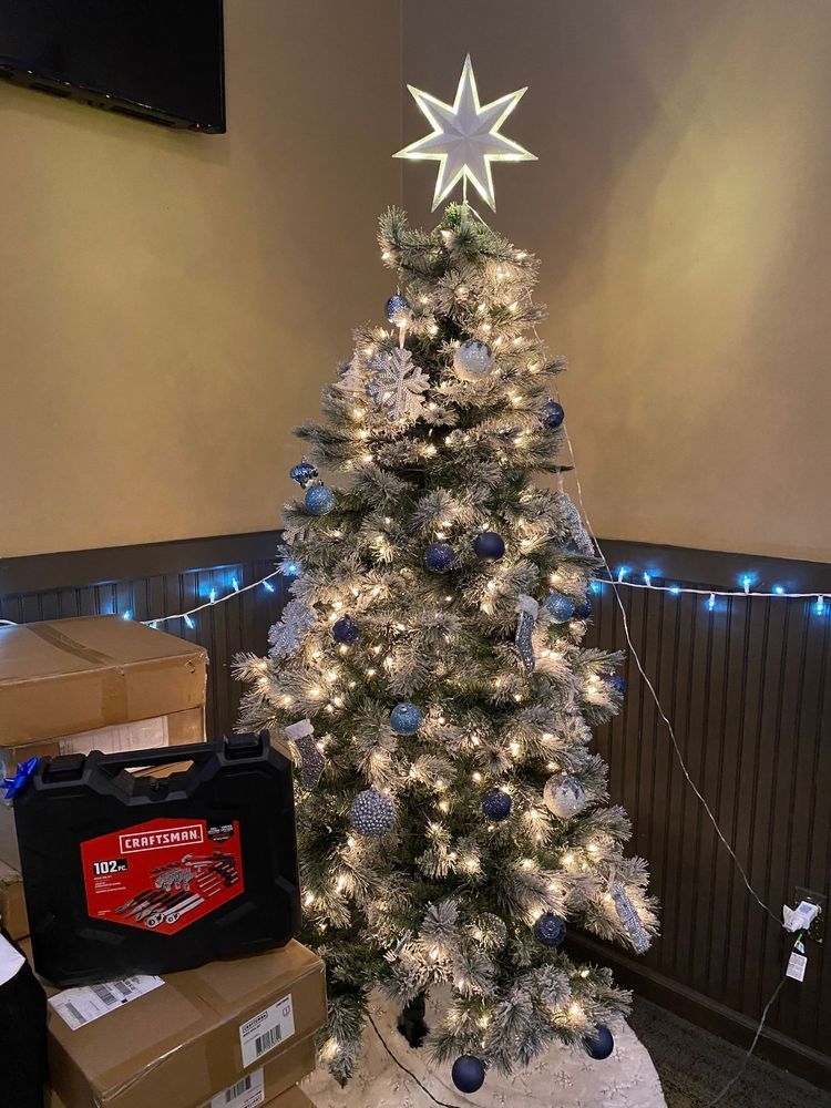 A christmas tree with blue and white decorations and a star on top.