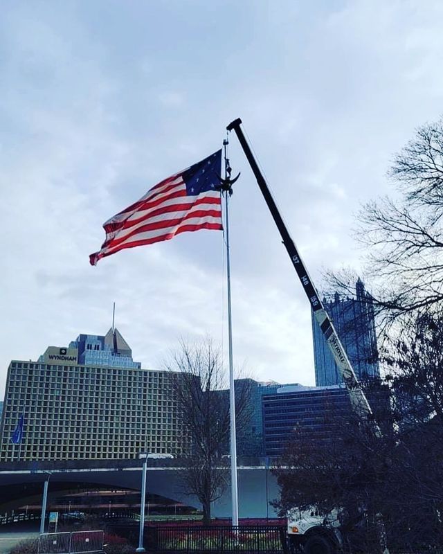 An american flag is flying in front of a large building