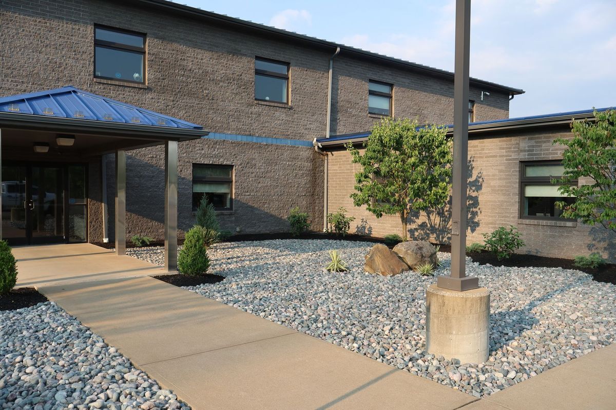 A building with a blue roof and a walkway leading to it
