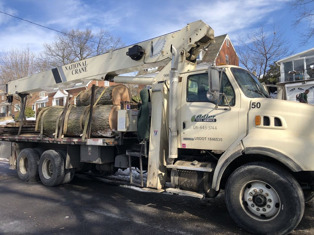 A large truck with a crane on the back is parked on the side of the road.