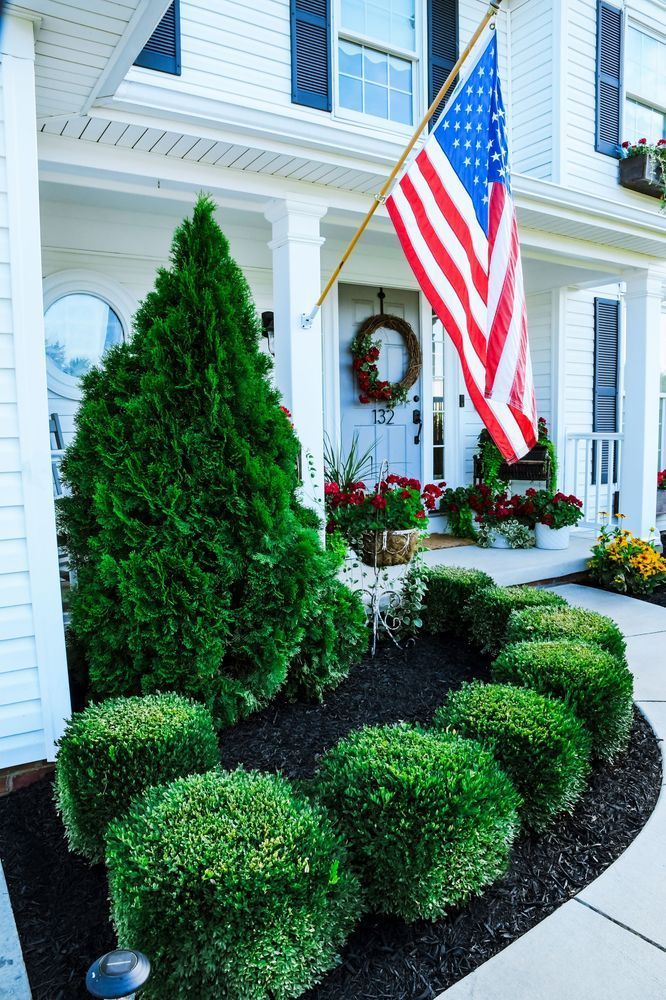 An american flag is flying in front of a white house.