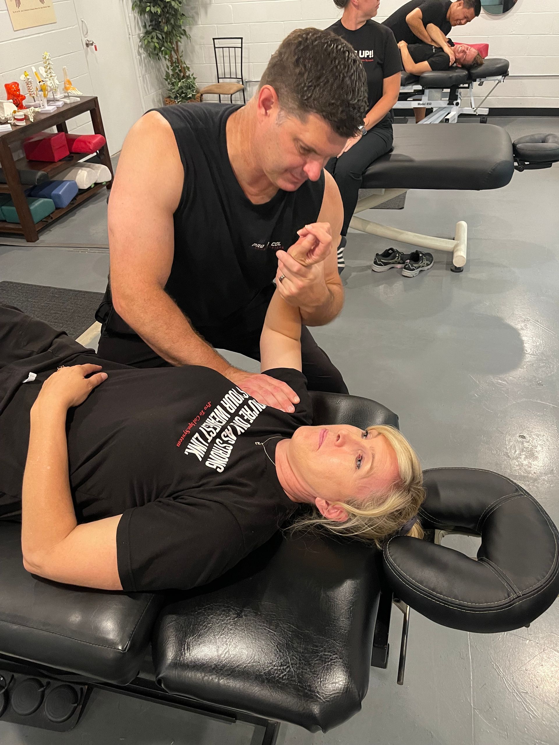 Chiropractor adjusting a patient lying on a treatment table in a clinic.