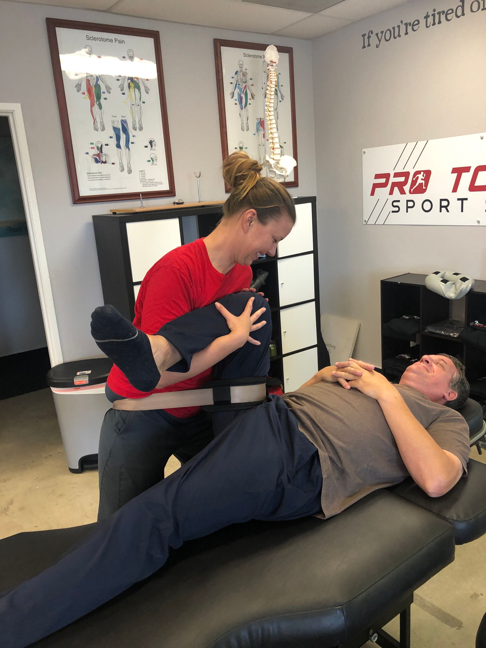Physical therapy session with a therapist assisting a patient on a treatment table in a clinic