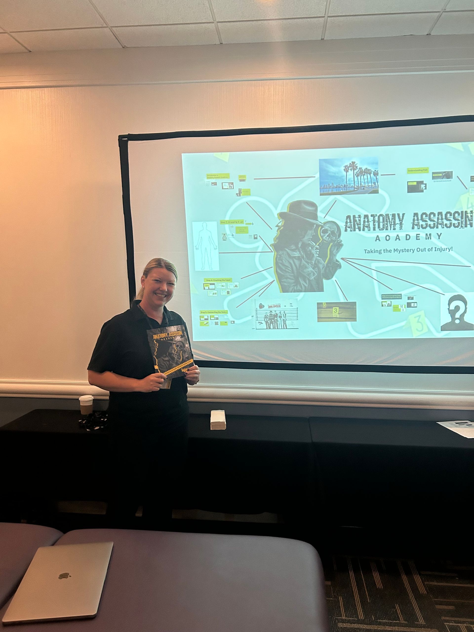 Presenter standing beside projected slide during classroom presentation with brain diagram and notes