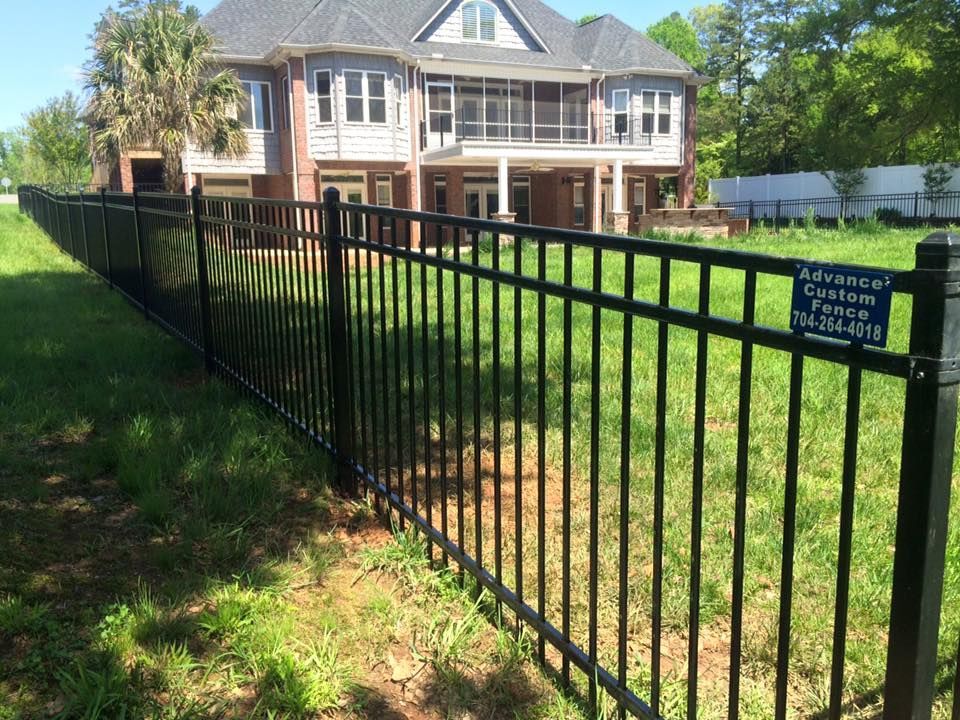 A large house with a black fence in front of it.