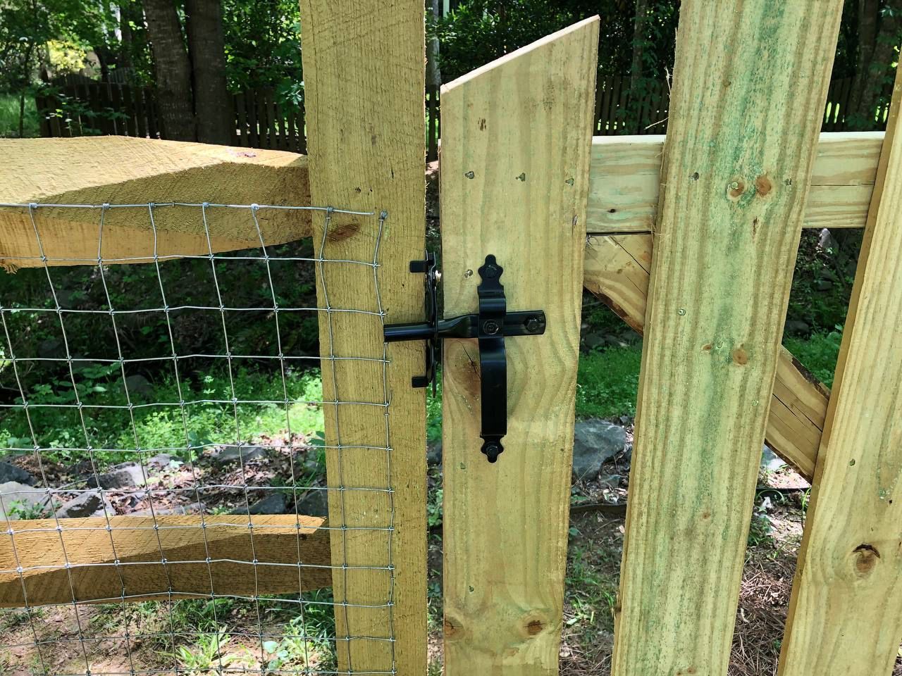 A close up of a wooden gate with a black cross on it.