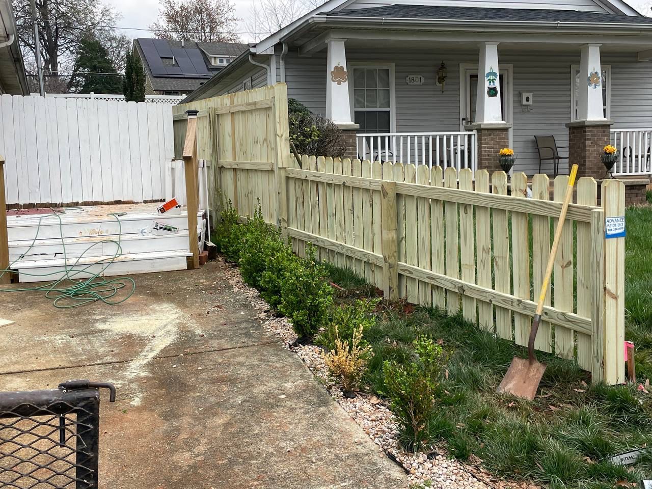 A wooden fence is being built in front of a house.