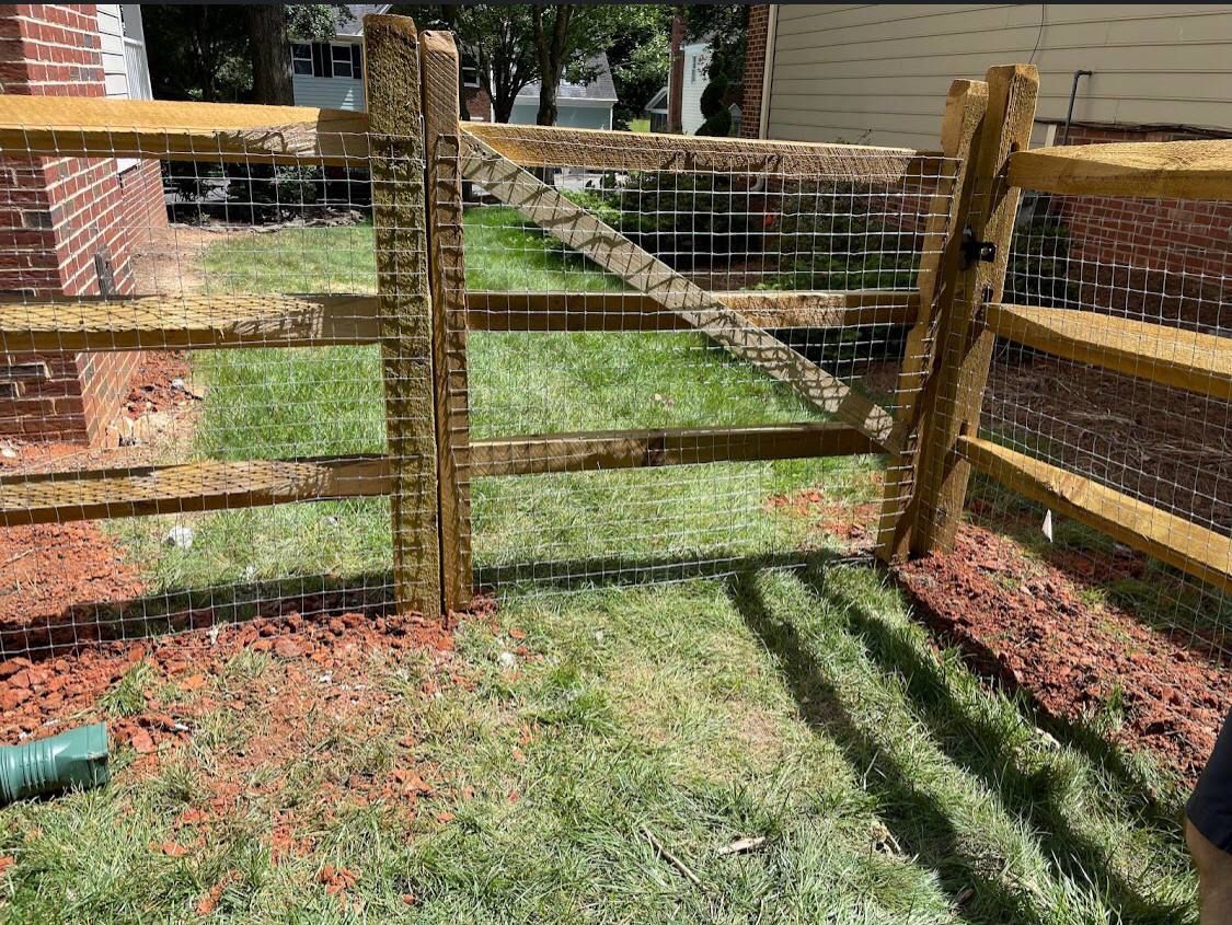 A wooden fence is sitting in the middle of a lush green yard.
