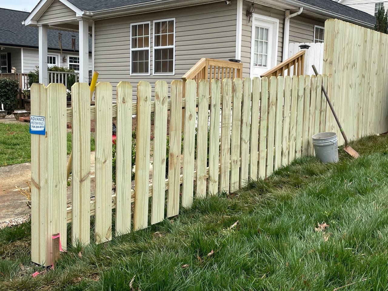 A wooden fence is sitting in front of a house.