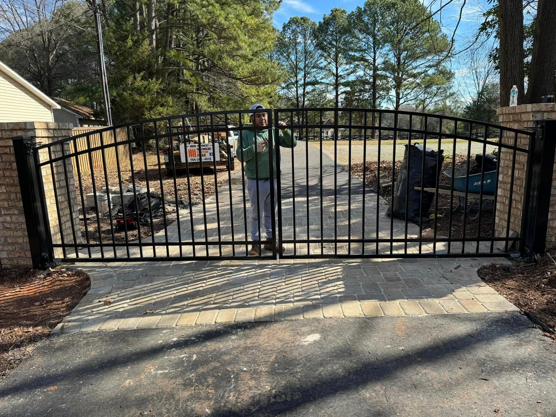 A man is standing in front of a wrought iron gate.