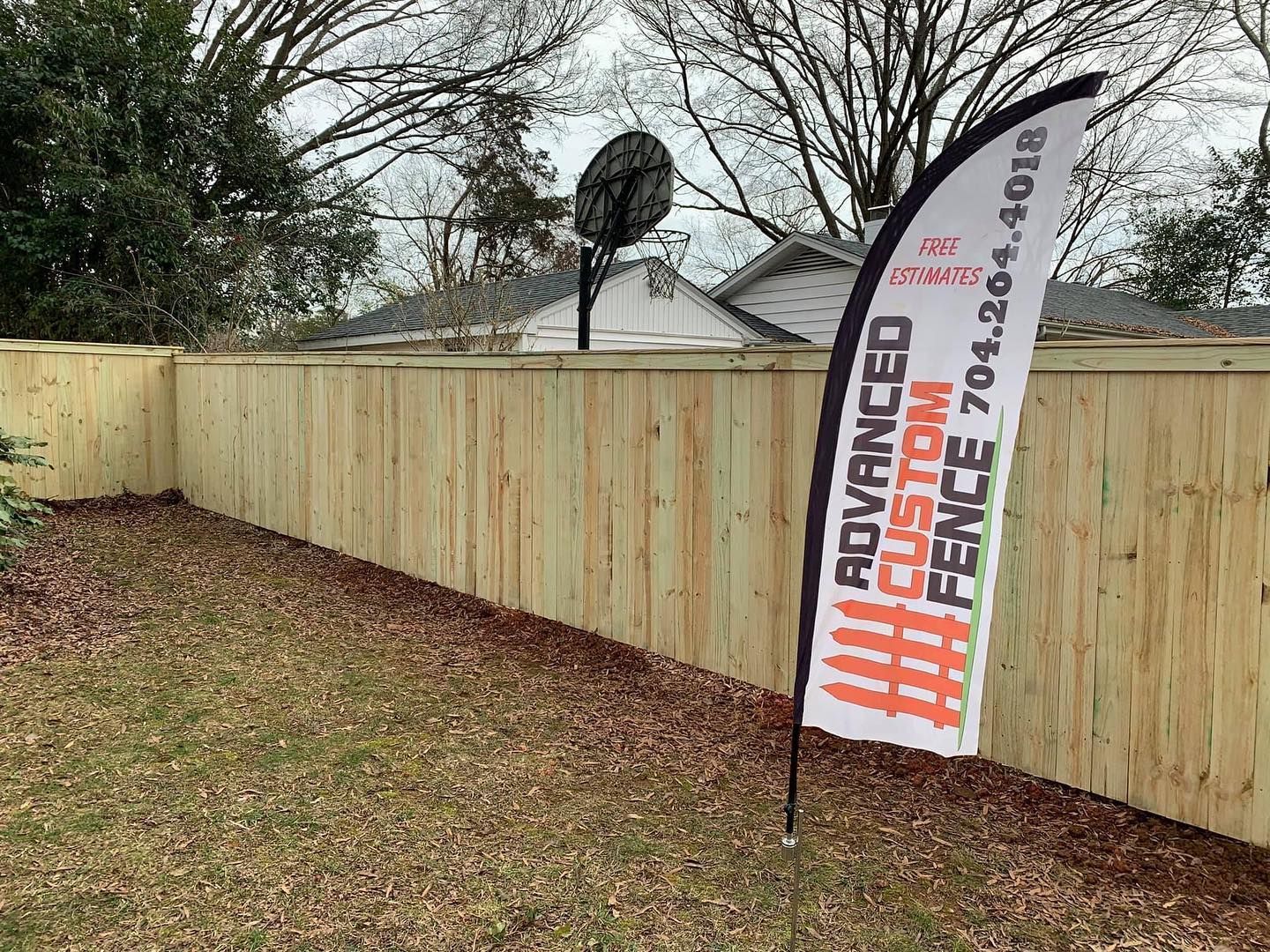 A wooden fence with a flag in front of it.