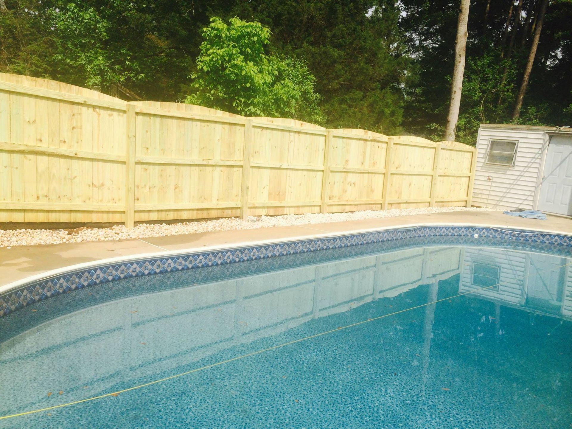 A swimming pool with a wooden fence around it