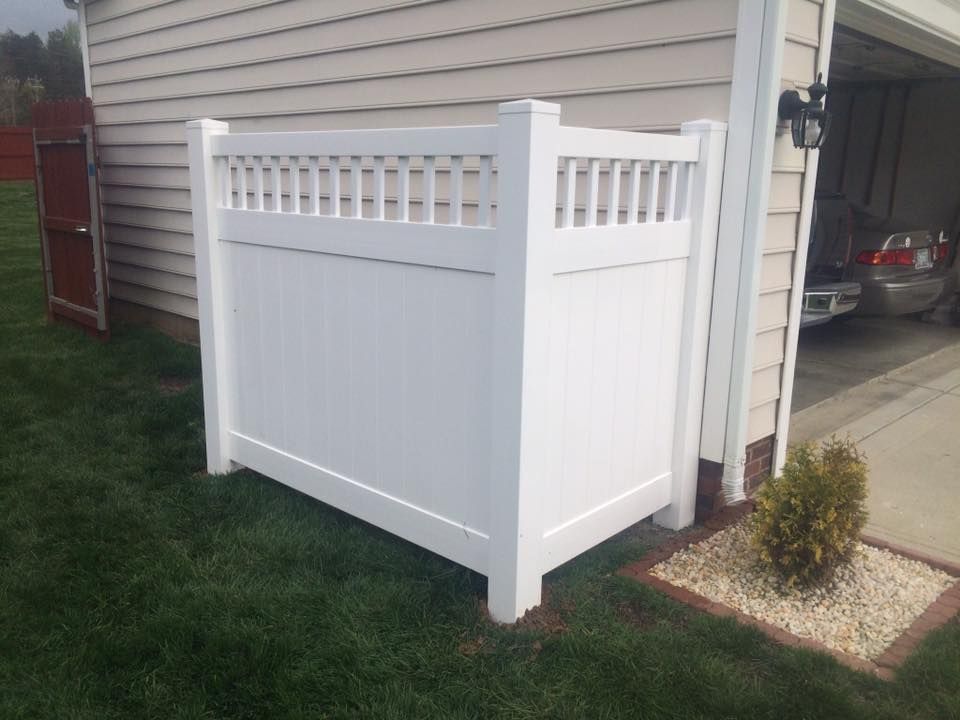 A white fence is sitting in front of a garage