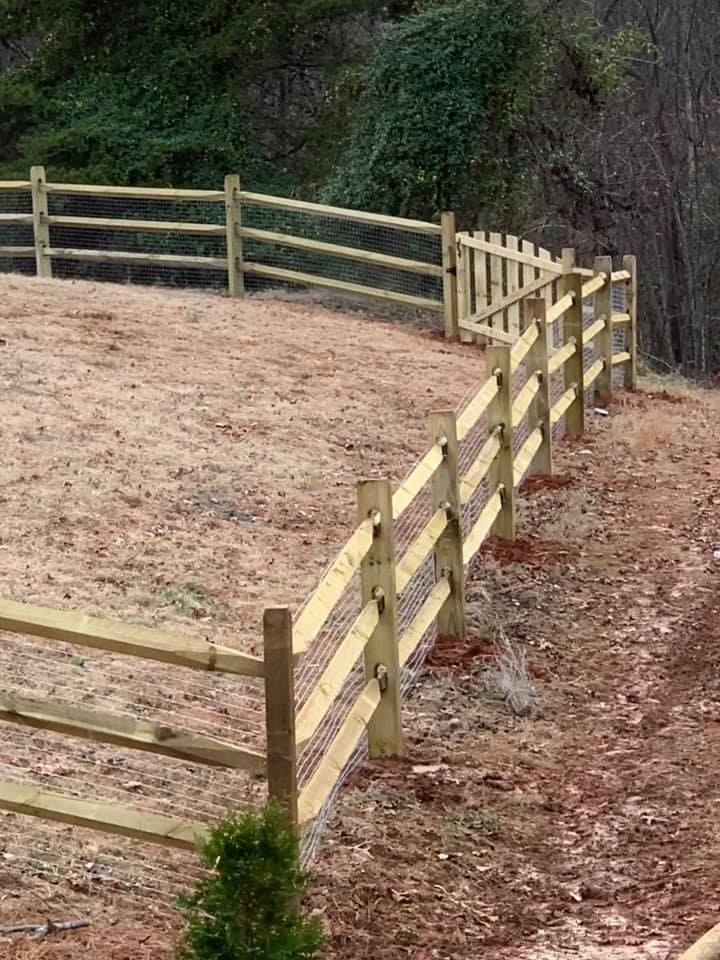 A wooden fence is sitting on top of a dirt hill.