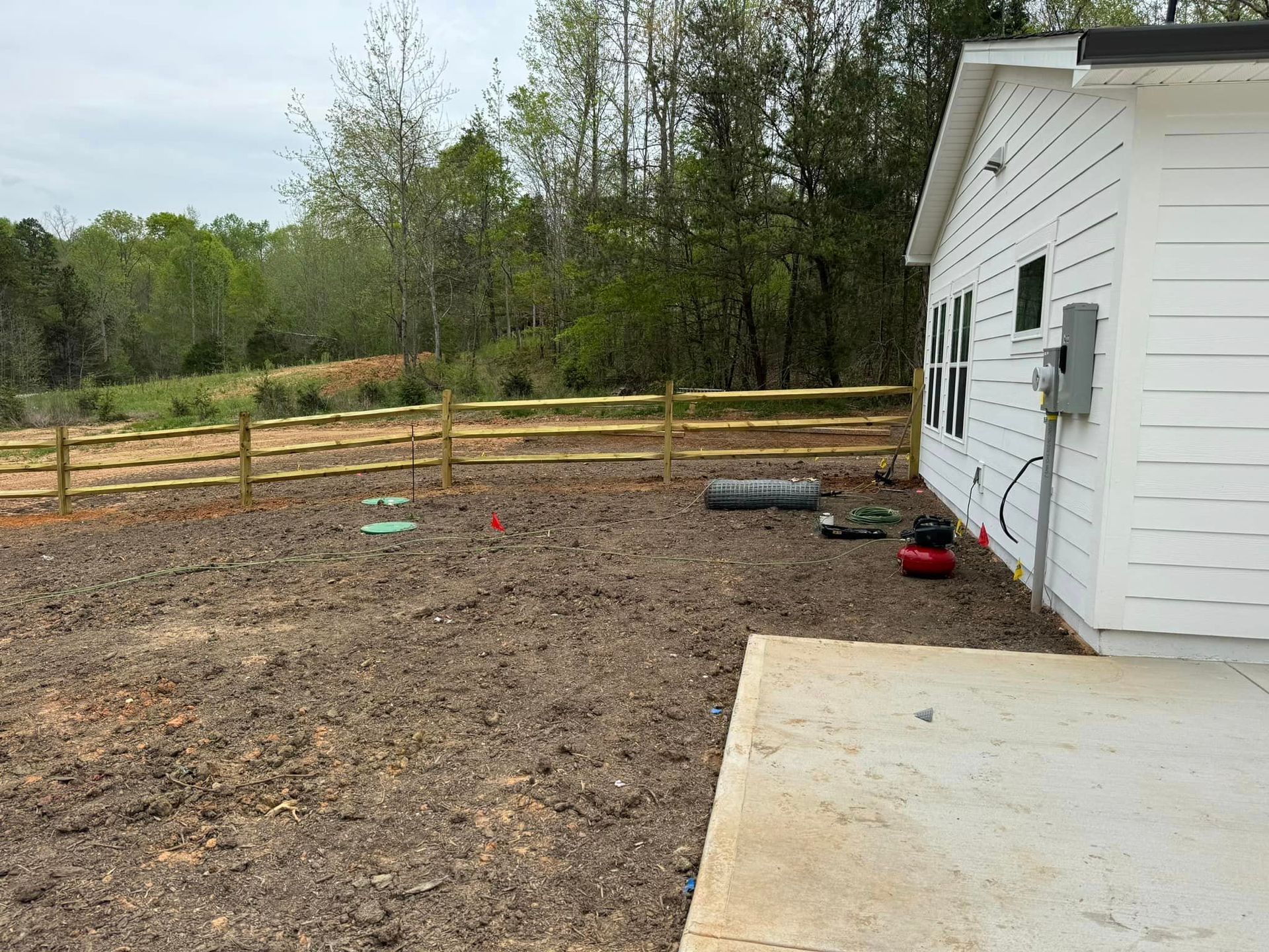 A white house with a wooden fence in the backyard.
