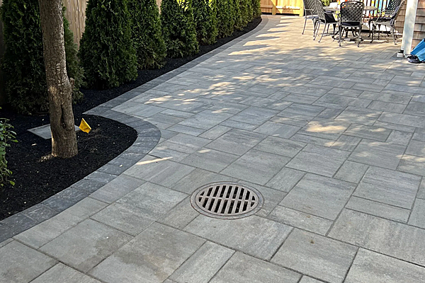 A patio with a table and chairs and a manhole cover.