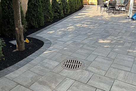 A patio with a table and chairs and a manhole cover.