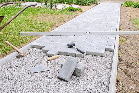 A walkway is being built with bricks and tools.