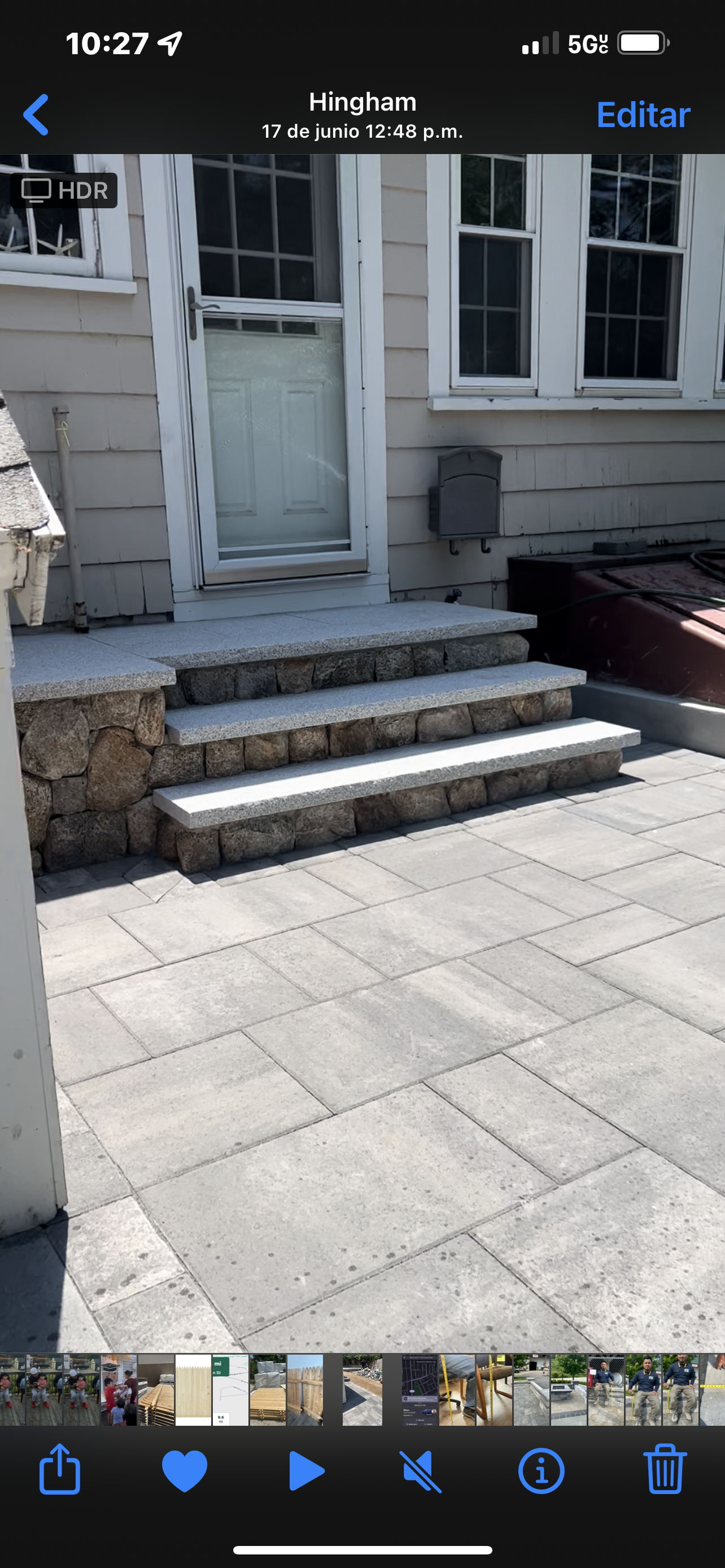 Stone steps leading up to a door of a light-colored house, surrounded by stone patio.