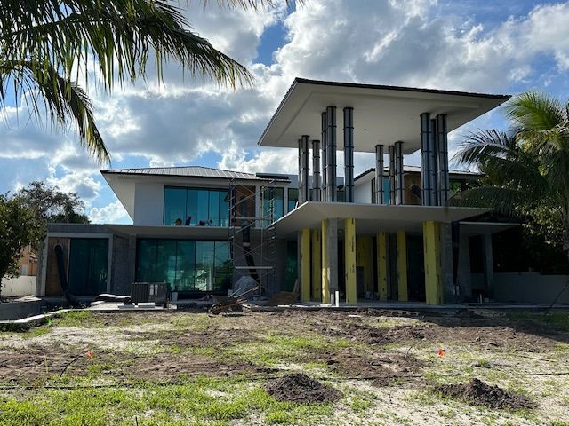 A large white house with a palm tree in front of it