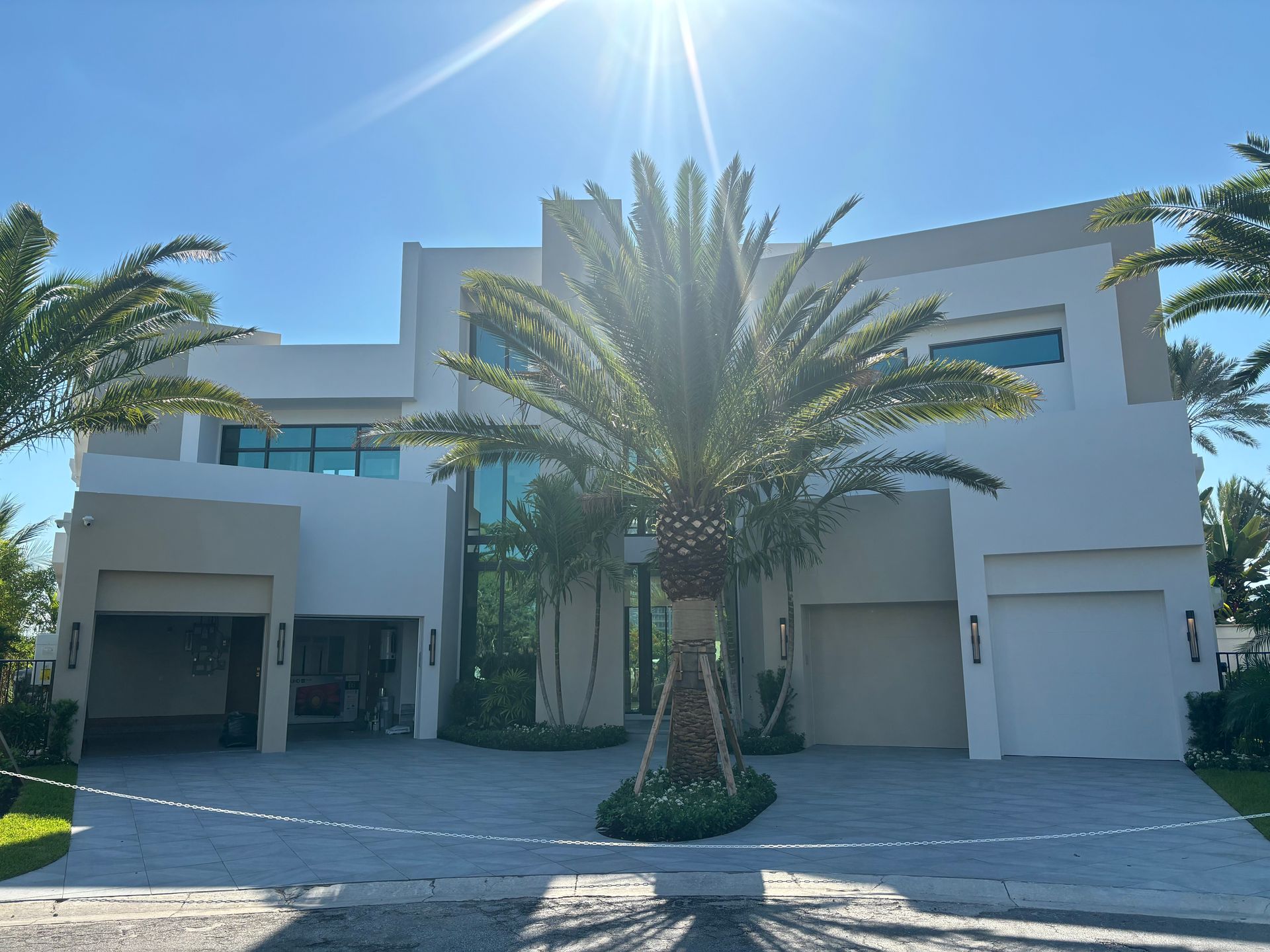 A large white house with a palm tree in front of it