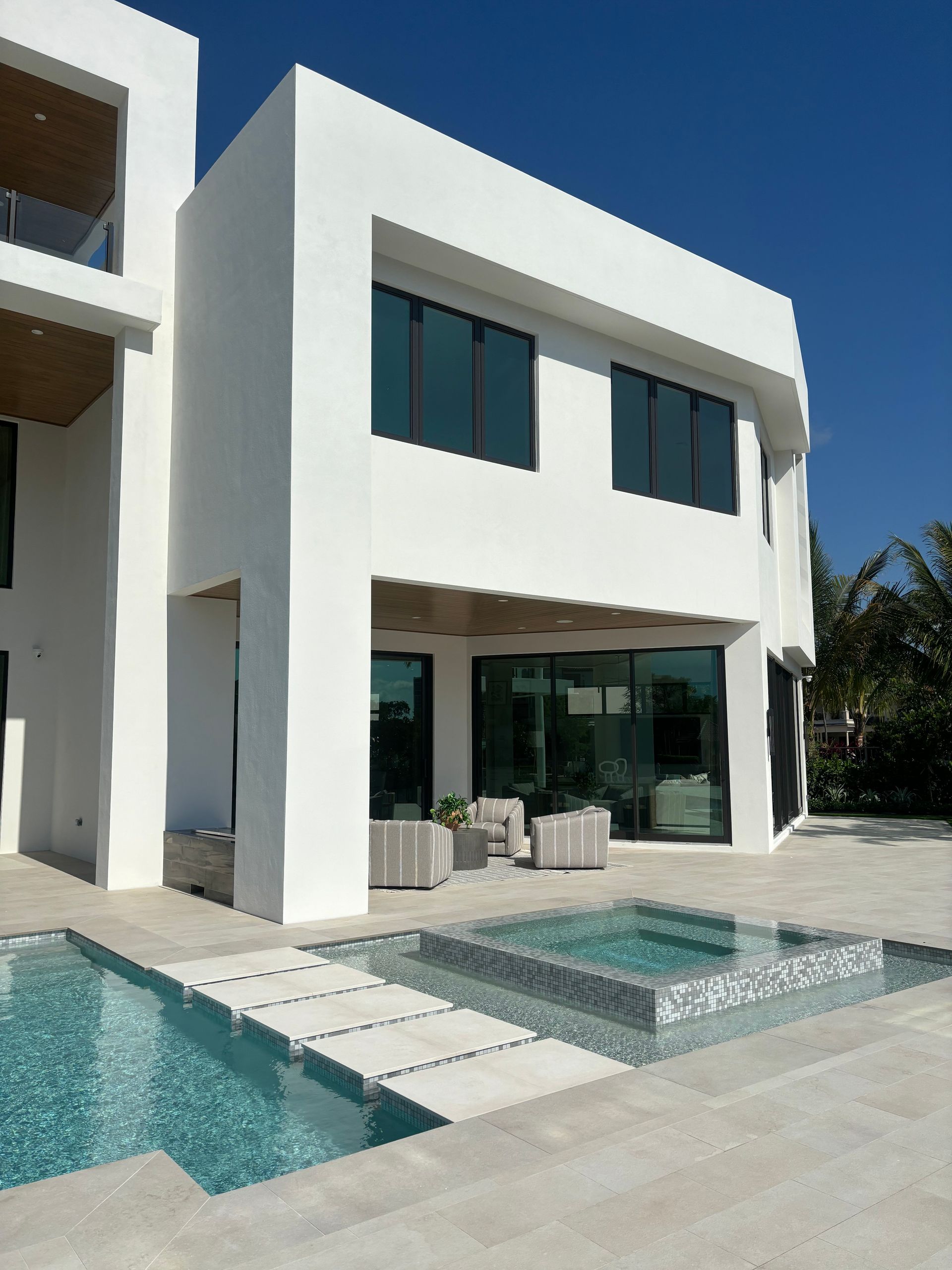 A large white house with a swimming pool in front of it