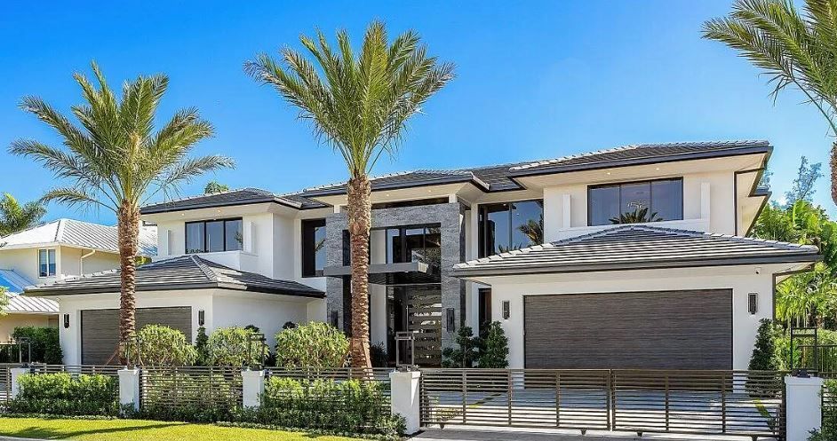 A large white house with palm trees in front of it.