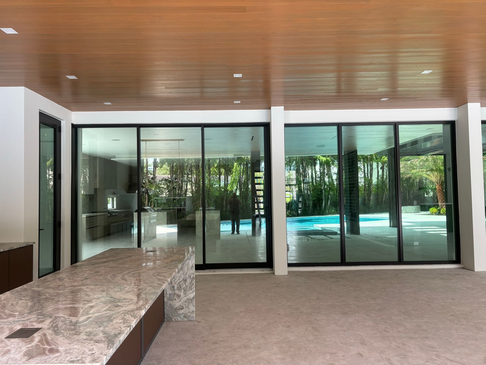 A large room with sliding glass doors leading to a pool.