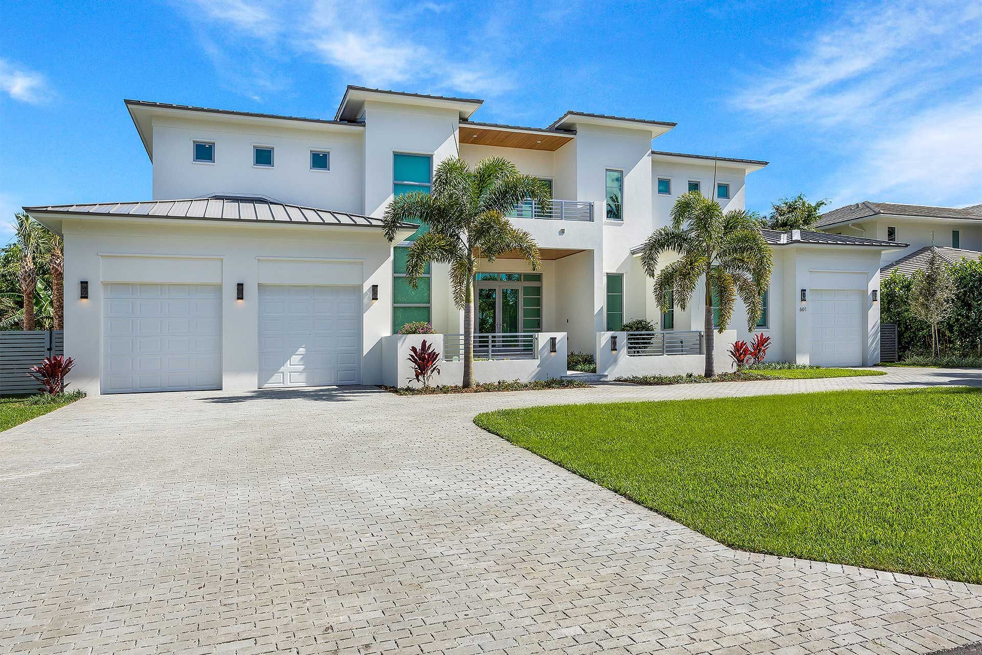 A large white house with two garages and a driveway