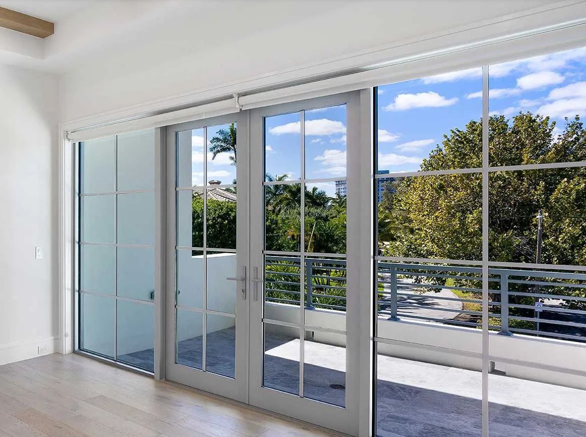An empty room with sliding glass doors leading to a balcony.