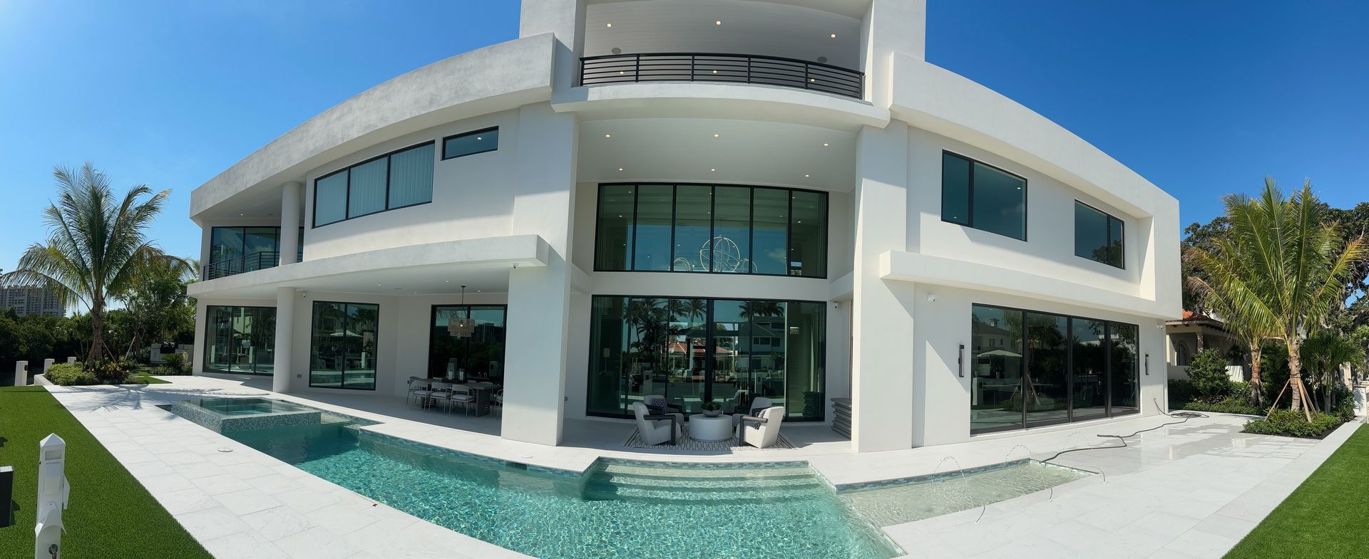 A large white house with a swimming pool in front of it.