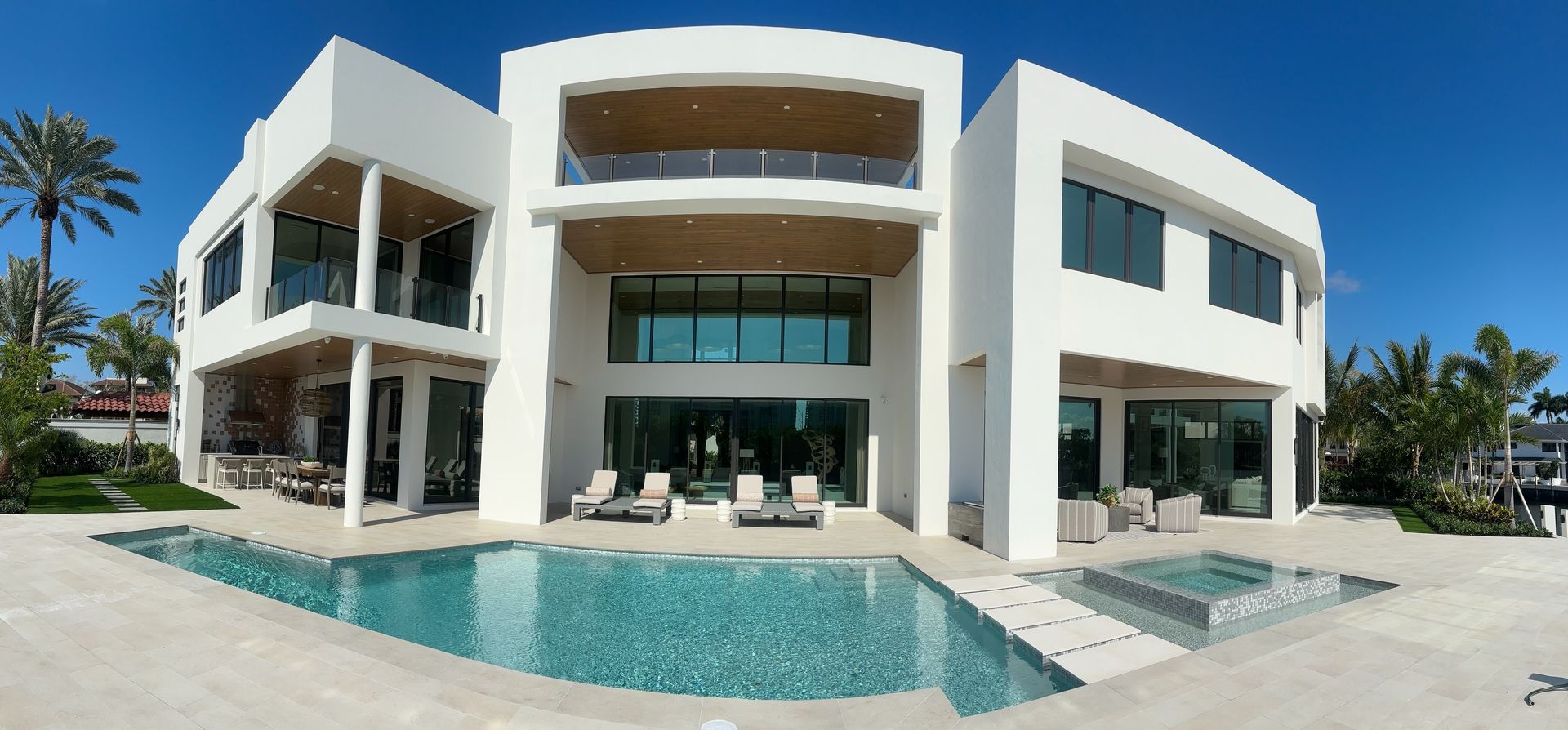 A large white house with a large swimming pool in front of it.