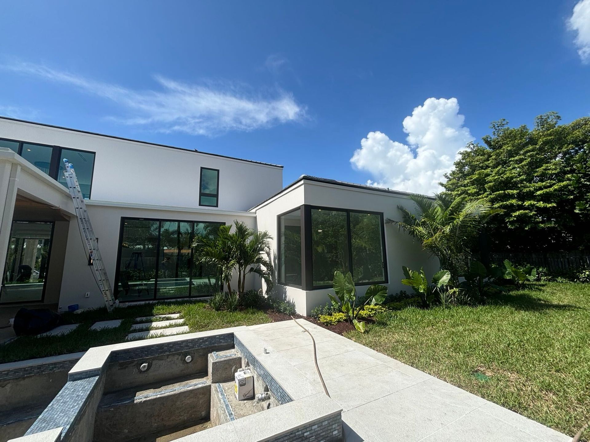 A large white house with a swimming pool in front of it