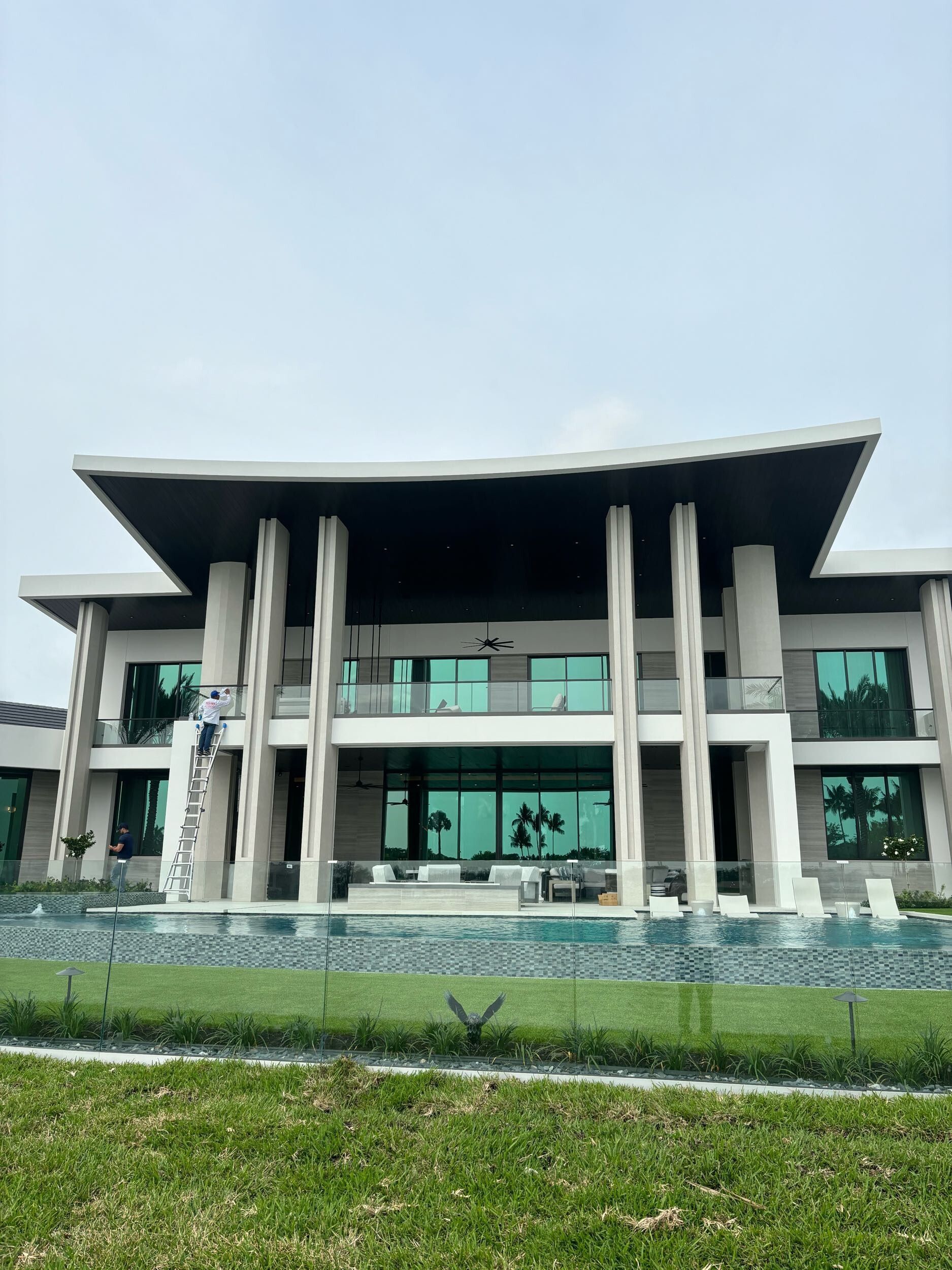 A large white house with a swimming pool in front of it.