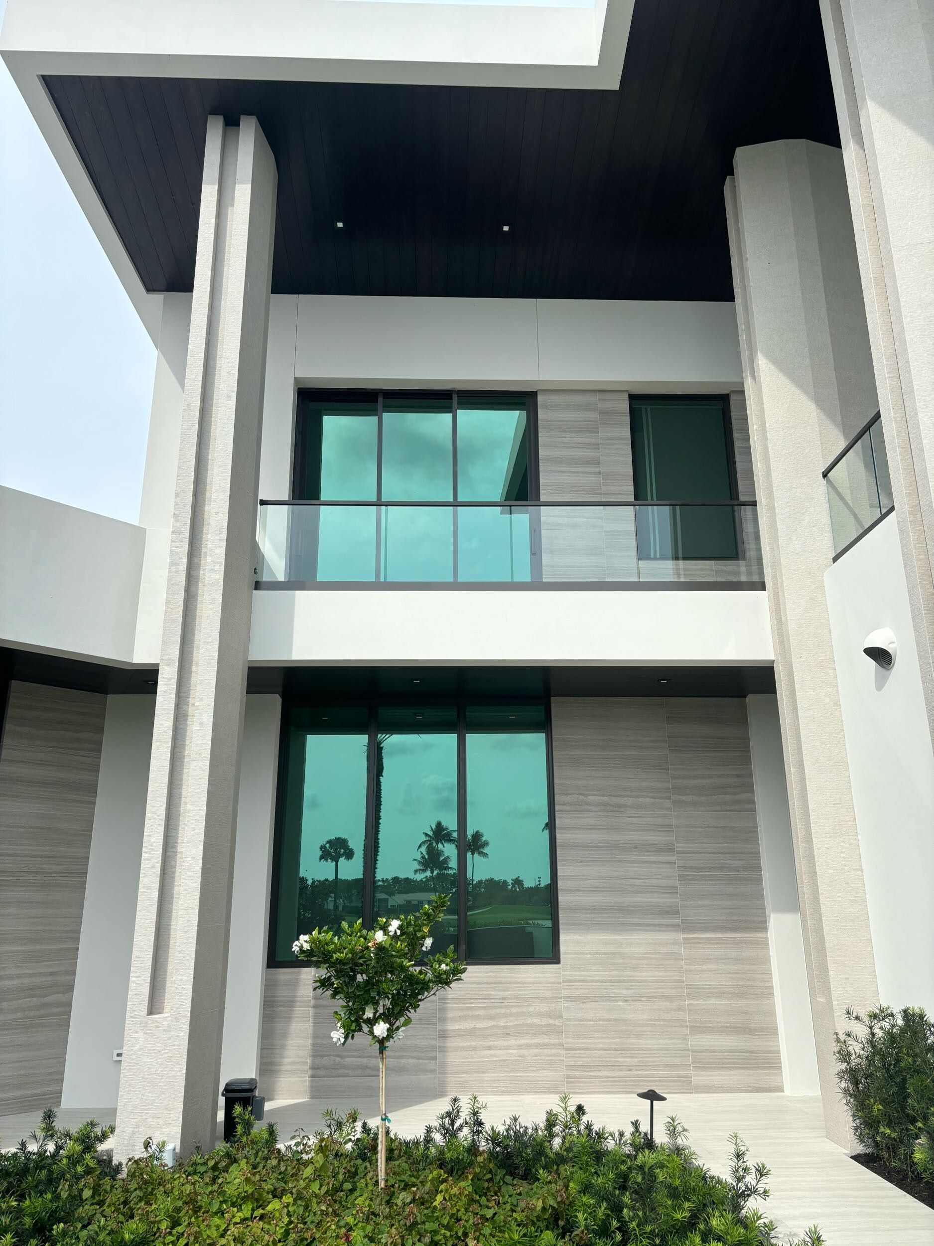 A large white house with a lot of windows and a balcony.