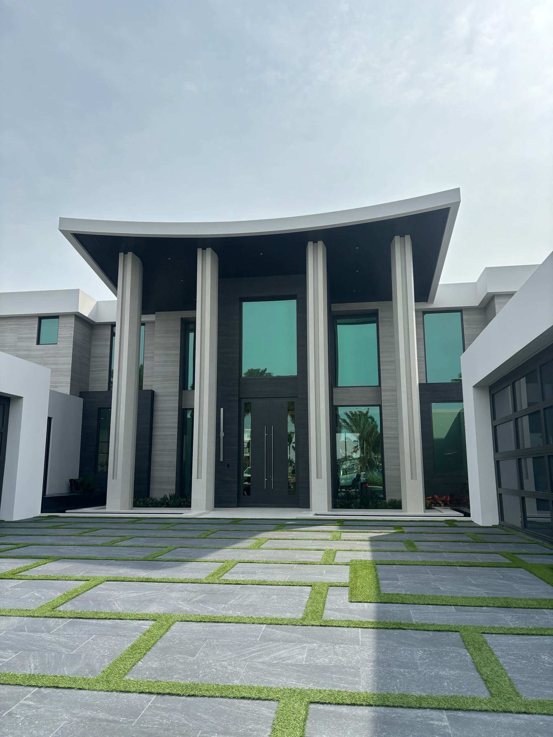 A large house with a brick driveway leading to it