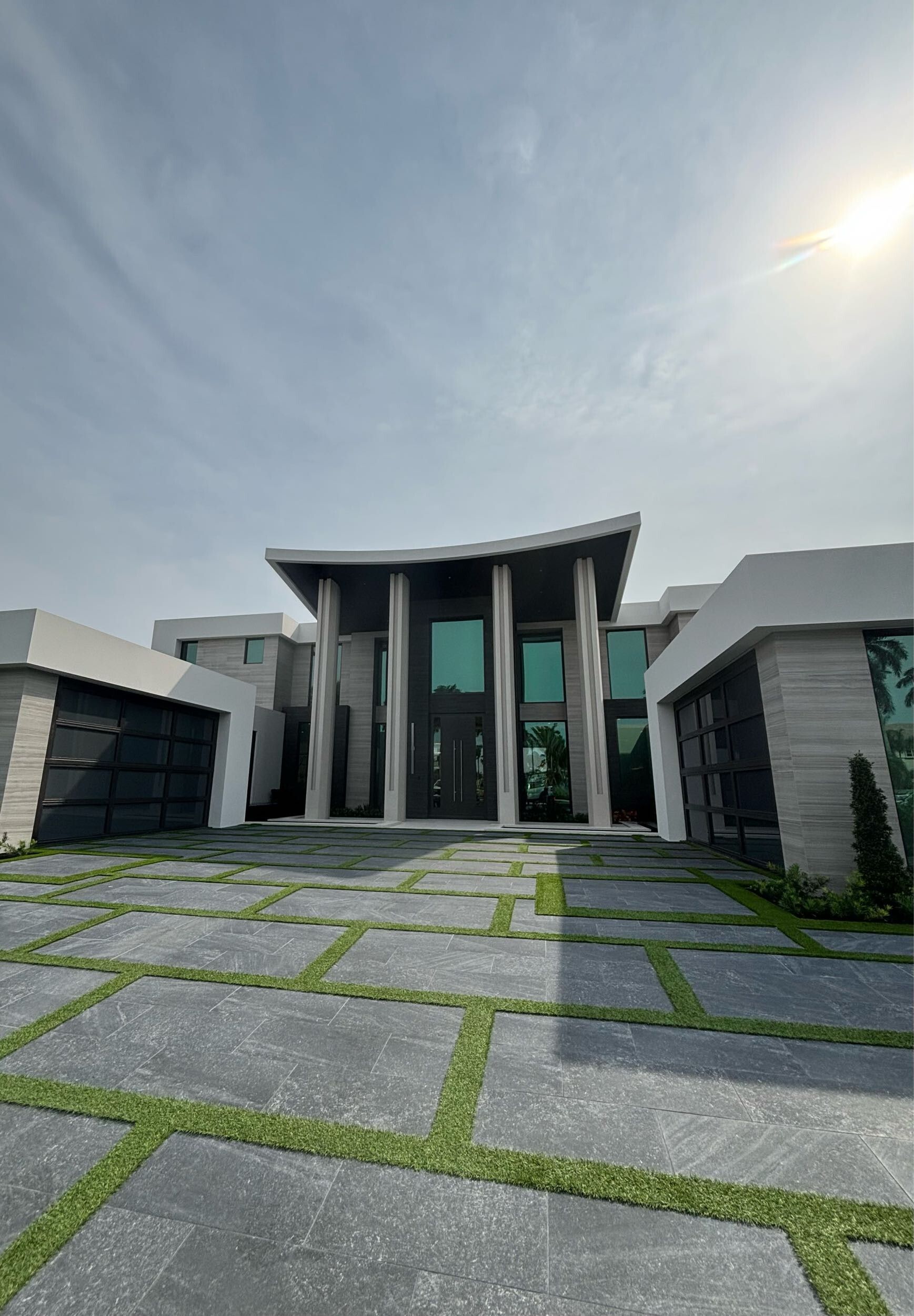 A large house with a lot of windows and a driveway leading to it.