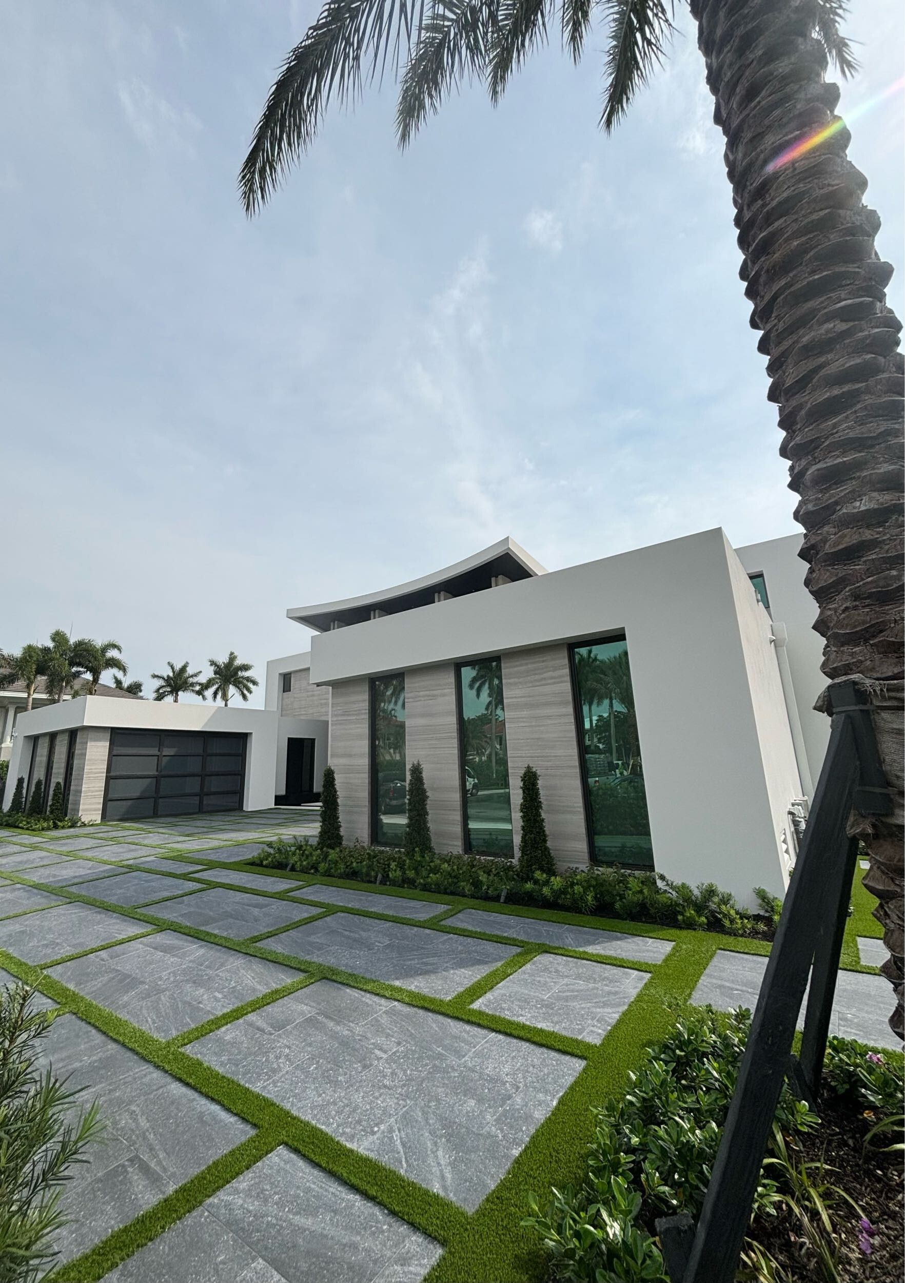 A large white house with a palm tree in front of it.
