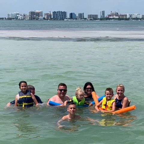 A group of people are floating on rafts in the ocean.