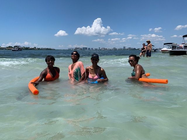 A group of women are floating on rafts in the ocean.