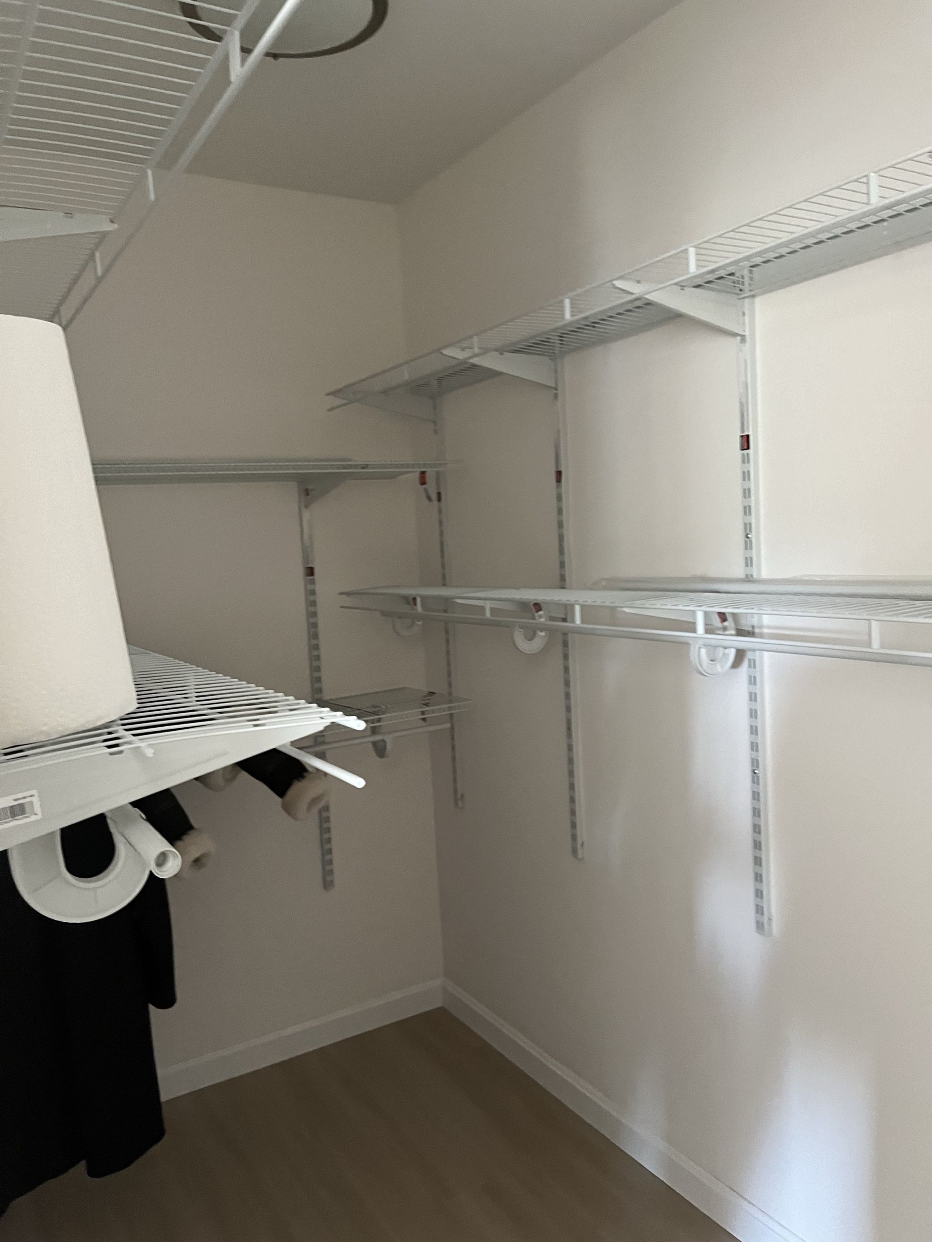 A walk in closet with lots of shelves and clothes hanging on them