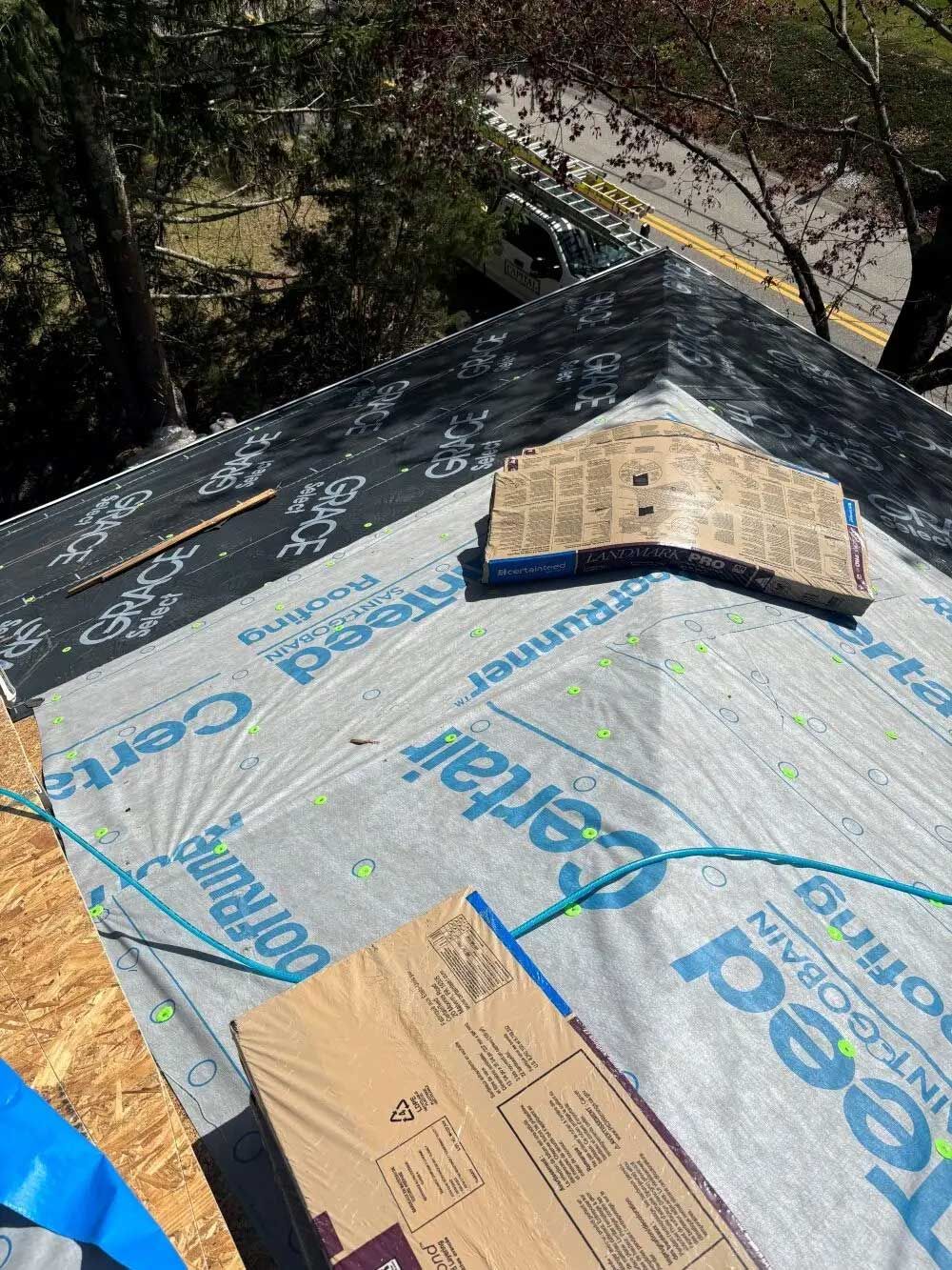 Roof under construction with protective underlayment and cardboard.