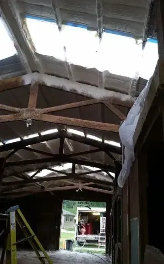 the inside of a building with a ladder and a van in the background