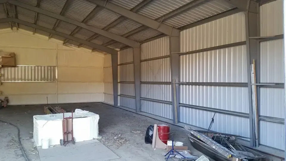 the inside of a large metal building with a concrete floor