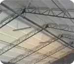 a close up of a metal structure with a ceiling fan hanging from it