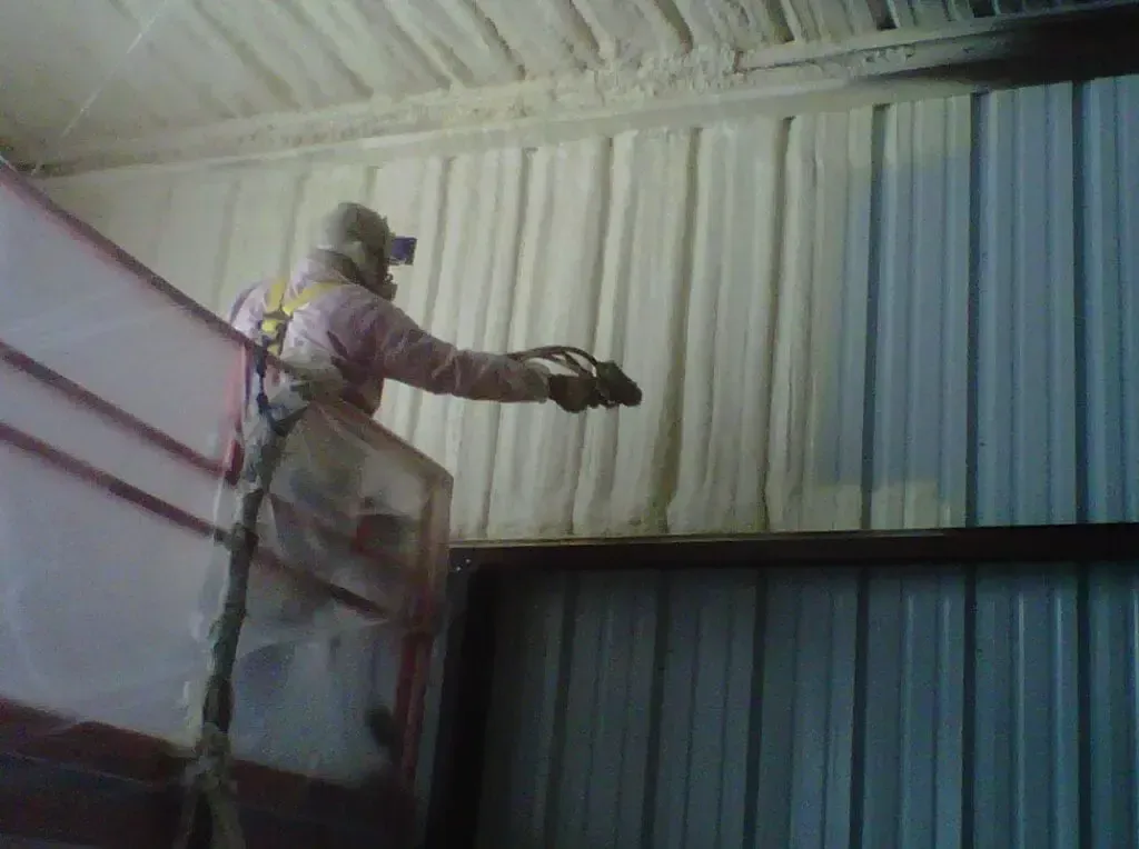 a man is spraying foam on the side of a building