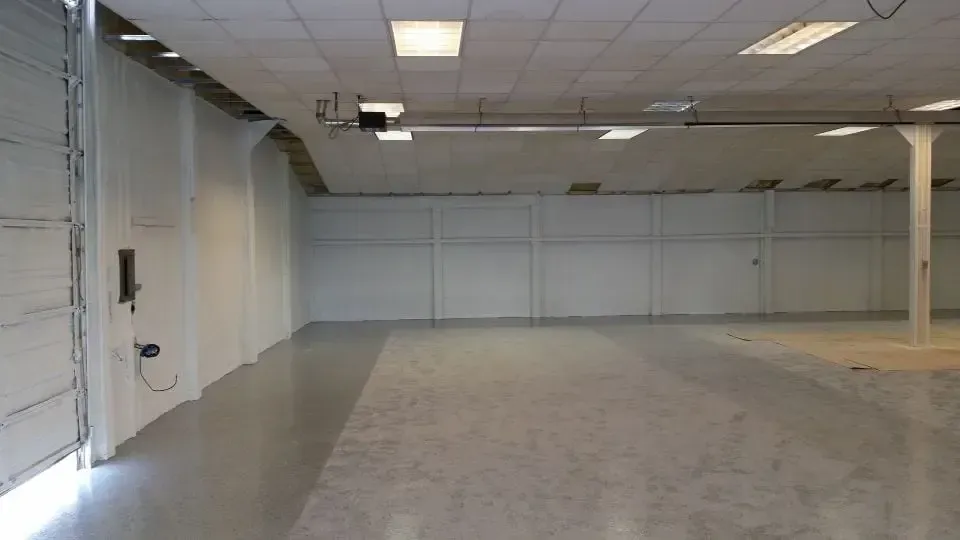 a large empty room with a garage door open