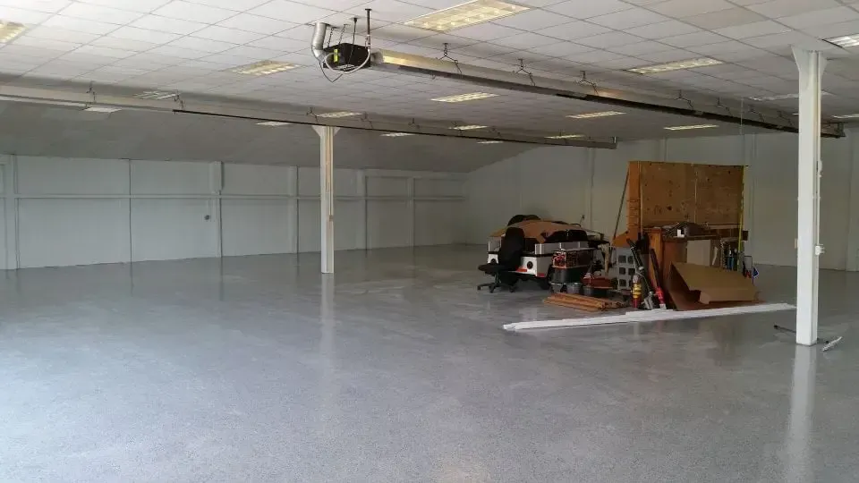 a large empty room with a garage door open