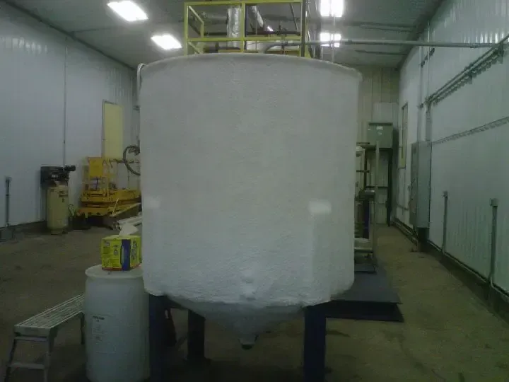 a large white tank is sitting in a warehouse